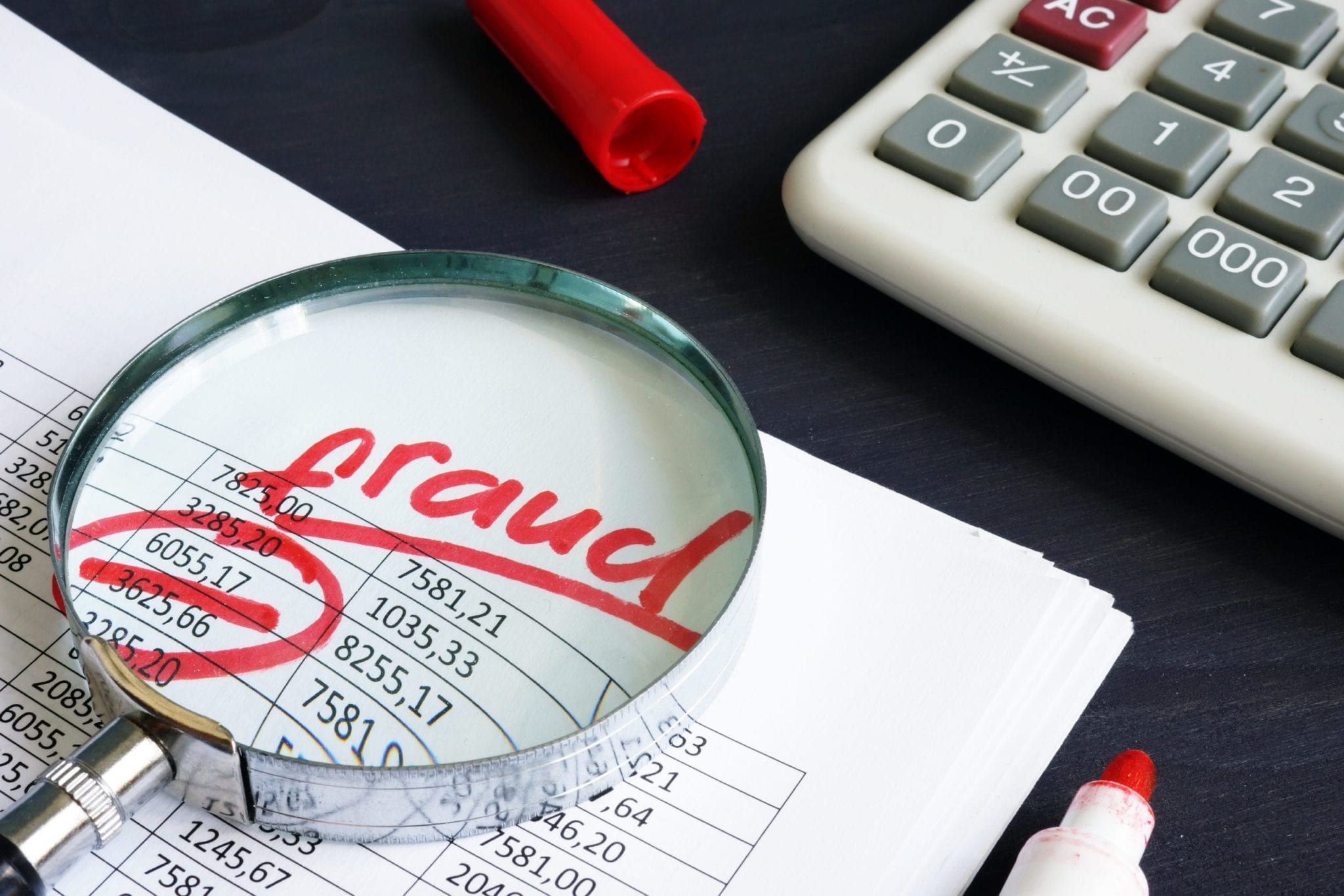 magnifying glass on accounting and payroll fraud