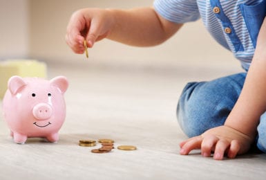kiddie tax | toddler investing money in piggy bank