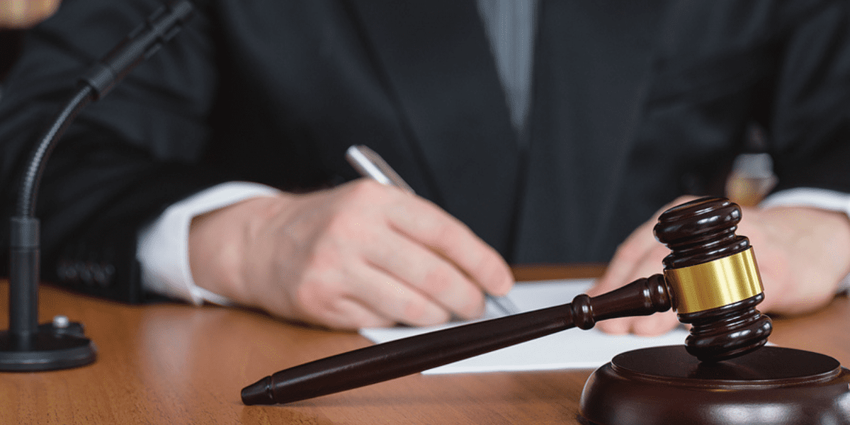 Corporate Transparency Act (CTA) Declared Unconstitutional in Court – What That Means for Your Business and BOI Requirements - a judge writes with a pen as his gavel sits in the foreground